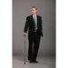 Man in a black suit holding a cane against a gray background