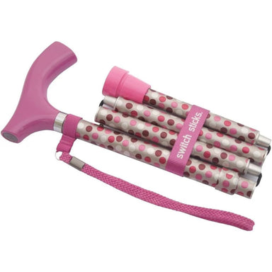 Pink walking cane with polka dot canes on a white background