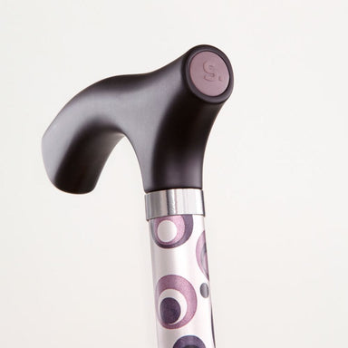 Cane with a patterned handle on a light gray background