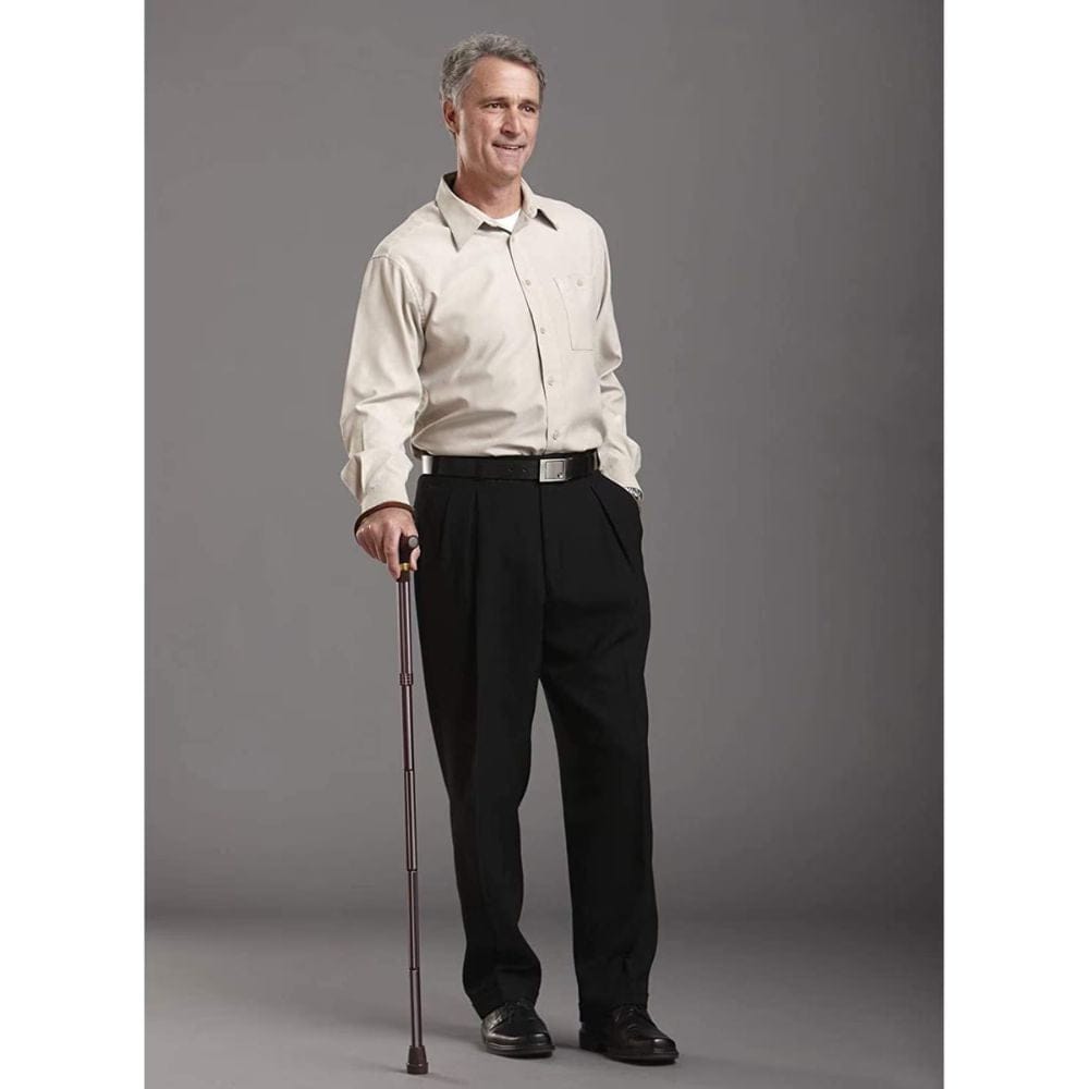 Man holding a cane against a gray background