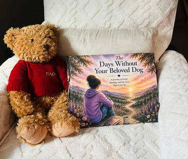 The Days Without Your Beloved Dog hardcover book displayed on a white chair beside a teddy bear