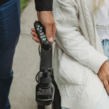 Person holding a remote control device with a blurred background