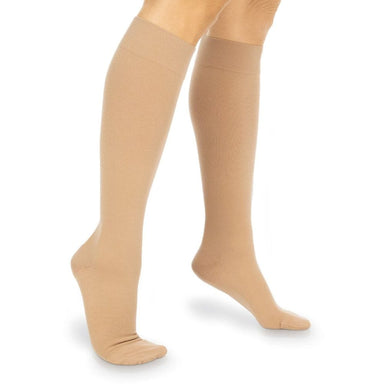 Beige knee-high socks worn by a person on a white background