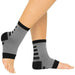 Gray and black compression socks on a person's legs against a white background