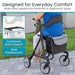 Person using a rollator with cushioned back support and wide padded seat, on a sidewalk.