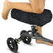 Person using a knee scooter with a black cushioned seat on a white background