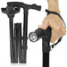 Black adjustable walking stick with flashlight attachment held by a hand on a white background