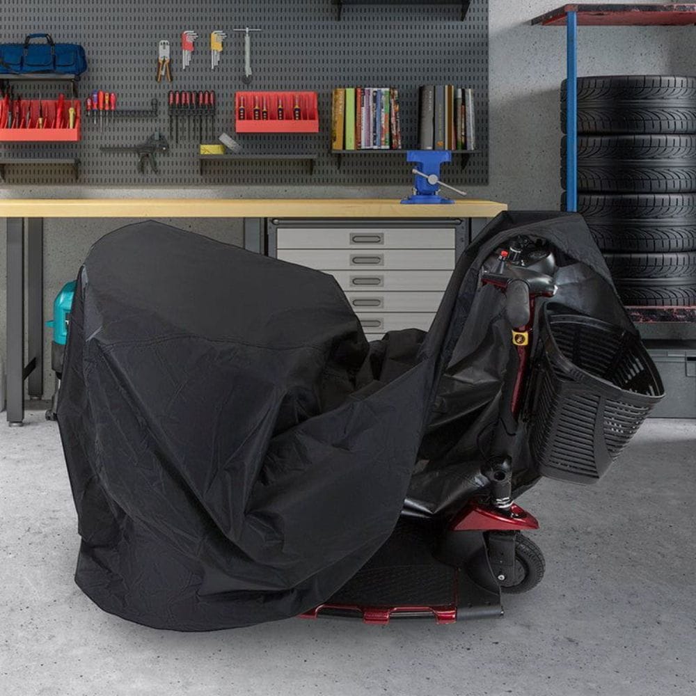 Black scooter cover on a scooter in a garage with tools and tires in the background