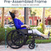 Person using a wheelchair with pre-assembled frame features, outdoors.
