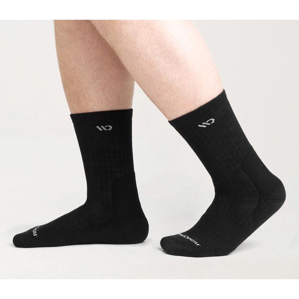 Black socks with a brand logo worn by a person on a light gray background