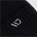 Close-up of a black sock with a white logo on a light gray background