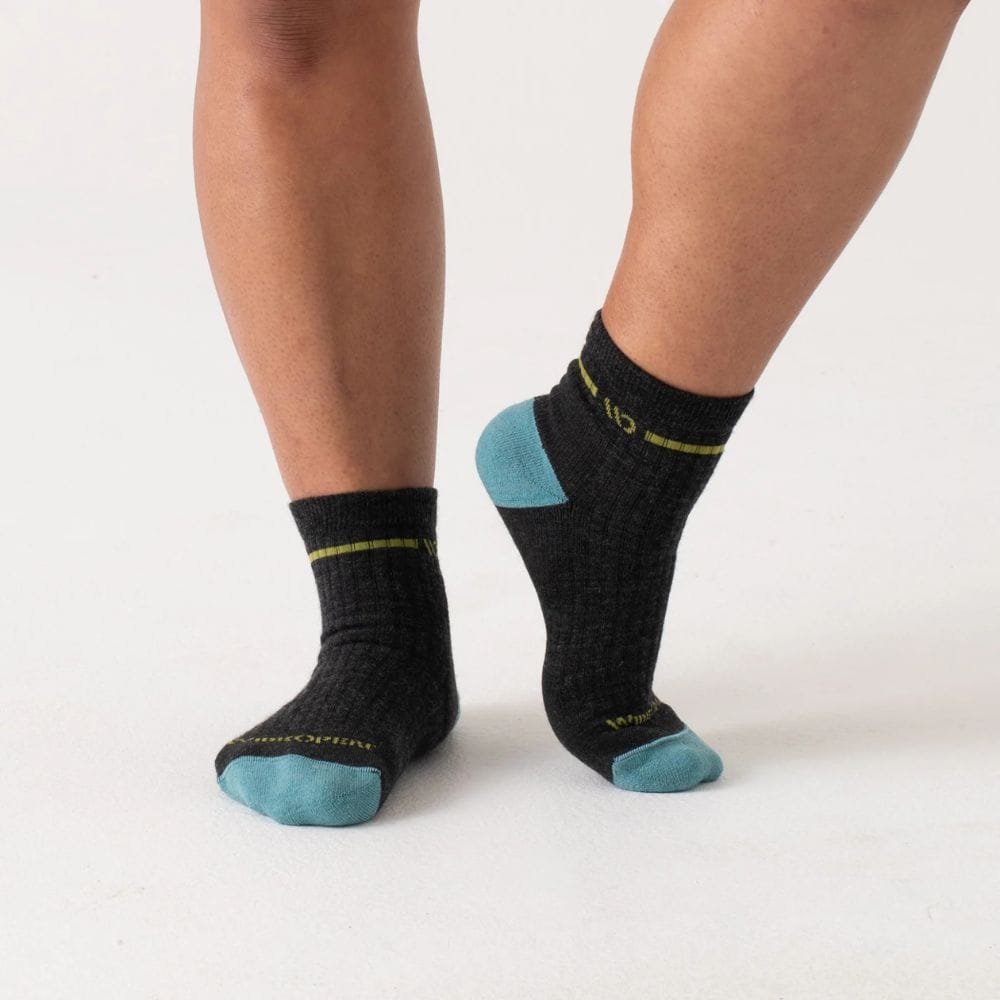 Black socks with blue toes and cuffs worn by a person on a white background