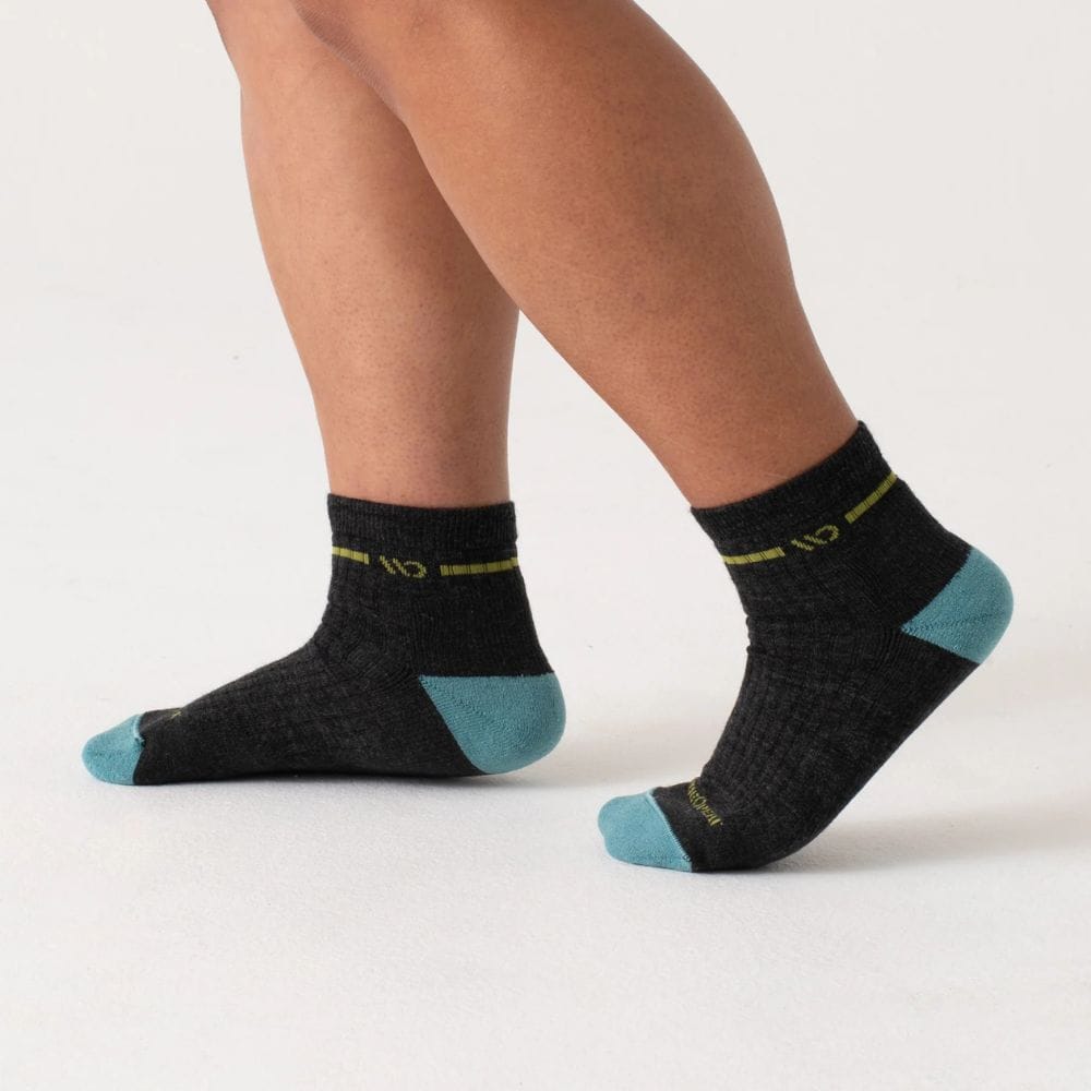 Black socks with teal accents worn by a person on a white background